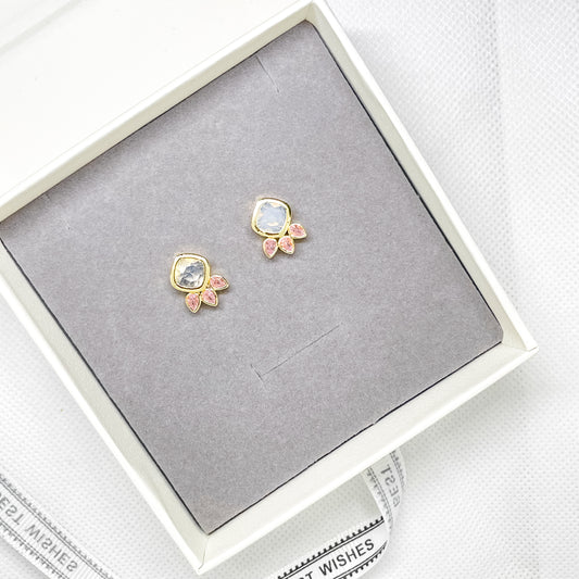 Gold stud earrings with clear crystal and pink crystal details displayed in a jewellery gift box