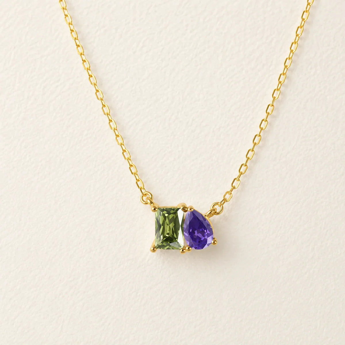 Lizabetha Parker gold birthstone necklace with green emerald and purple amethyst gems