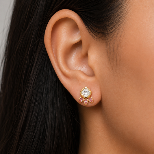 Pink crystal stud earrings with gold setting worn on ear