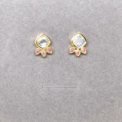 Close-up of gold stud earrings with clear crystal centre and pink marquise crystal details