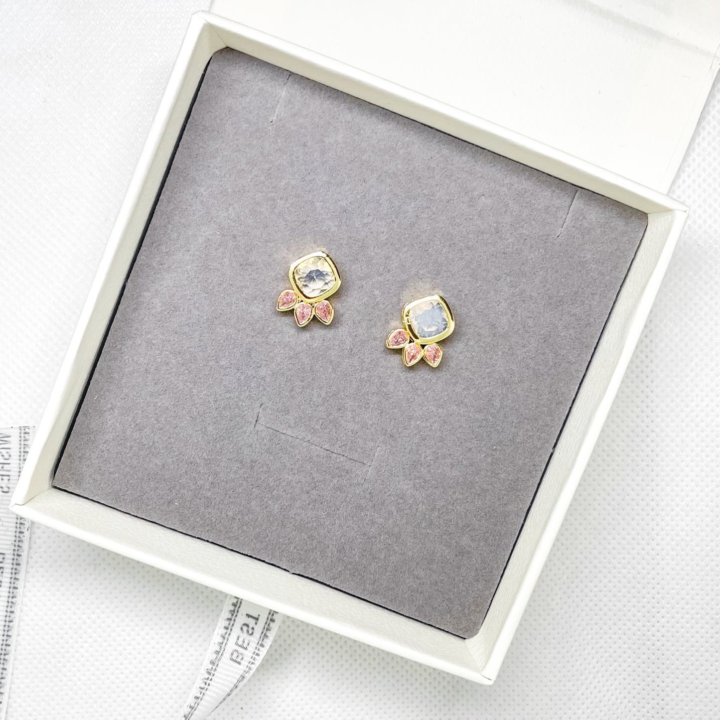 Gold stud earrings with clear crystal centre and pink marquise crystal details in a jewellery gift box