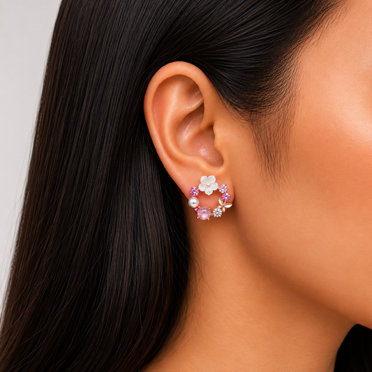 Model wearing pink floral crystal stud earrings with pearl accents and rose gold finish.
